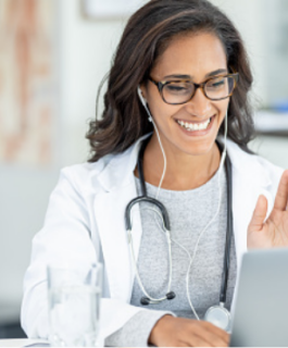 Doctor smiling and waving during a Telehealth appointment.