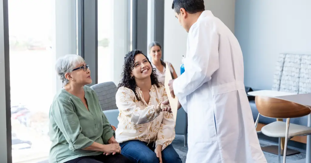 physician shaking hands with patients in a hospital waiting room