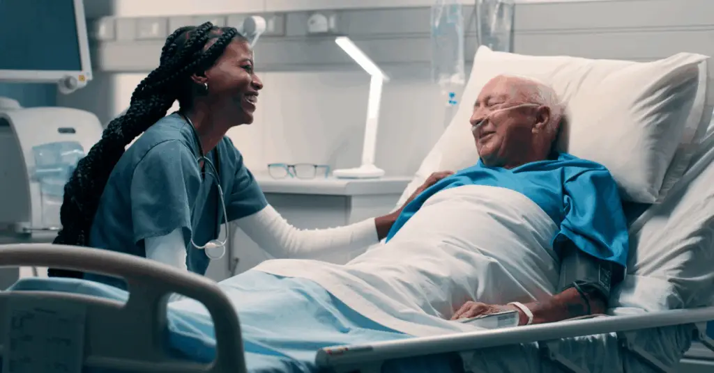 physician smiling at patient in hospital bed