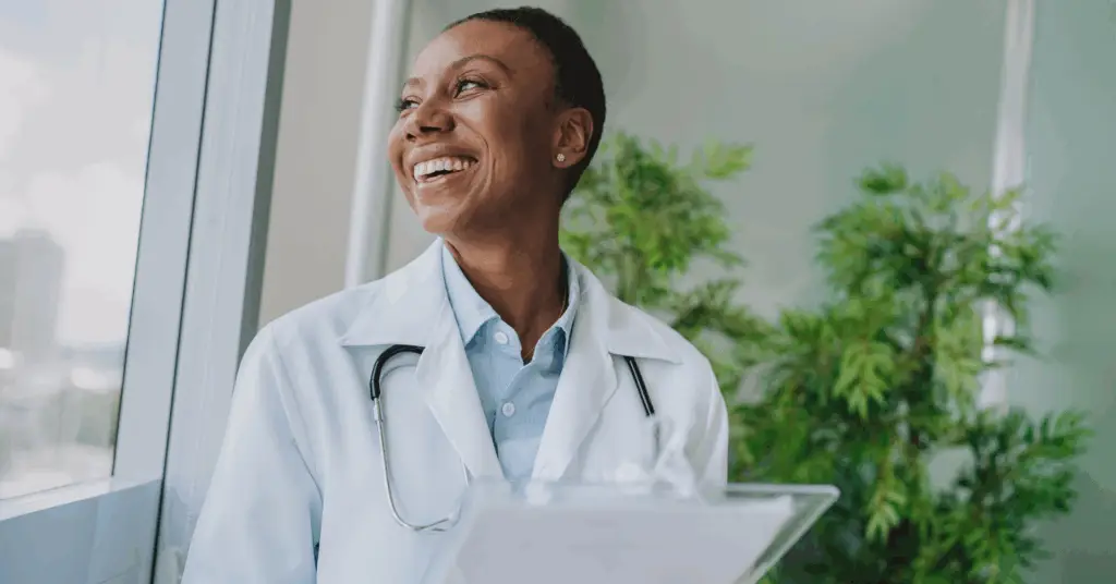 female doctor smiling while looking out the window