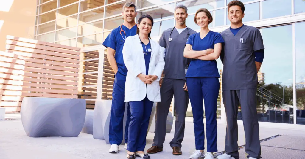 group of doctors smiling outside of hospital
