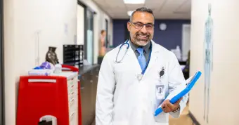 physician smiling at the camera in a hospital setting