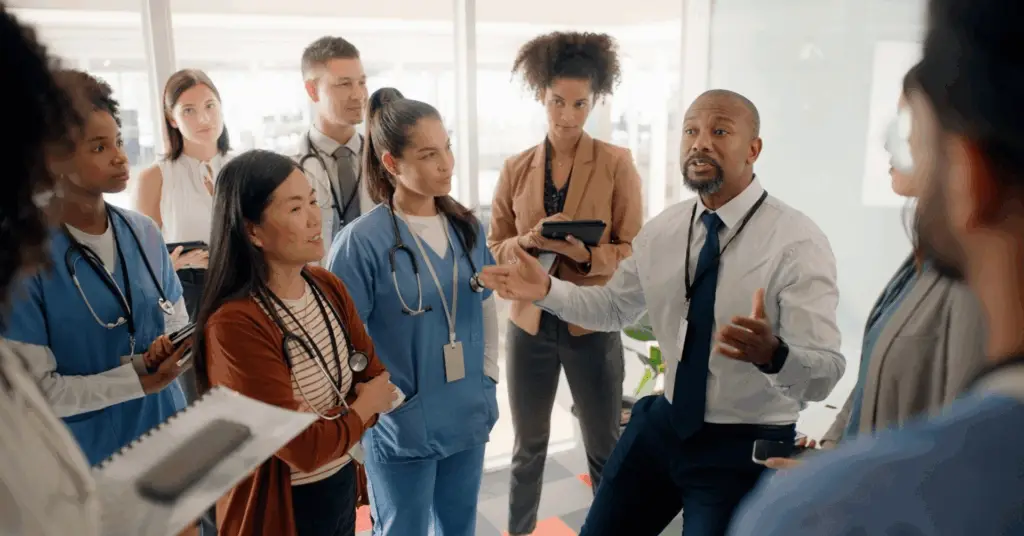 group of medical professionals talking in a hospital conference room