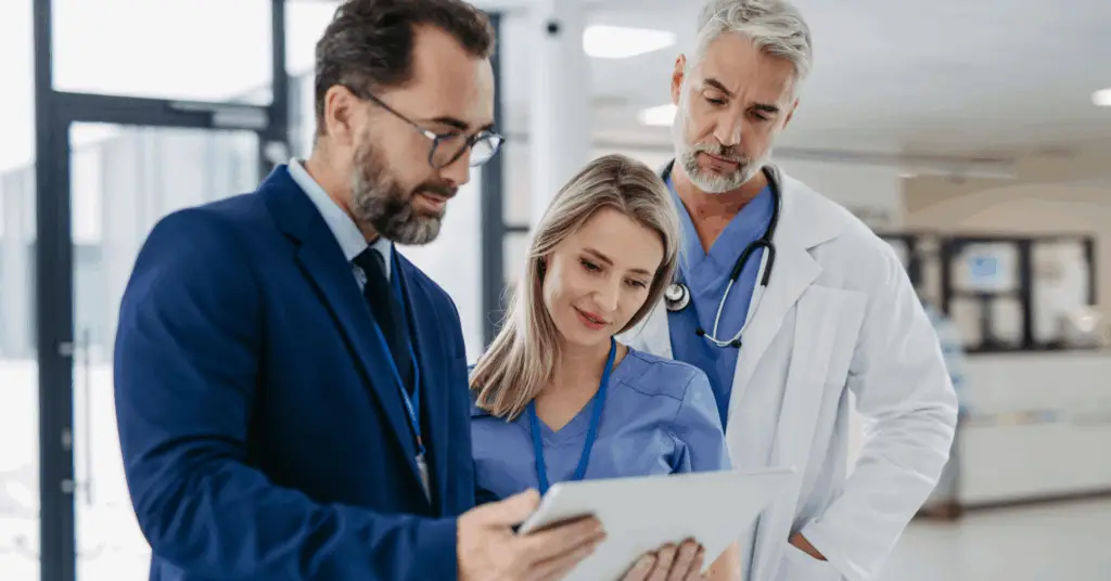 hospital executive speaks to two medical professionals