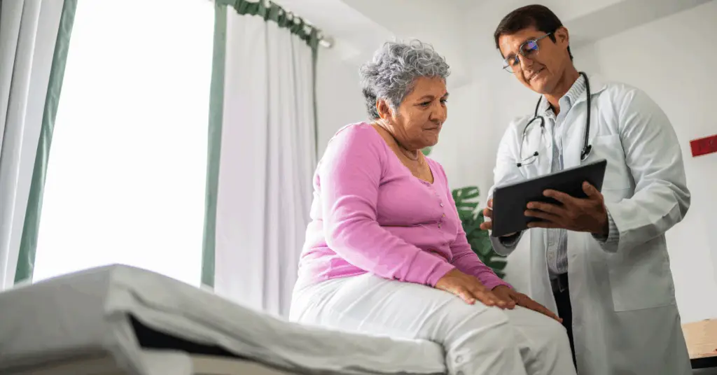 male doctor talks to a female patient in exam room