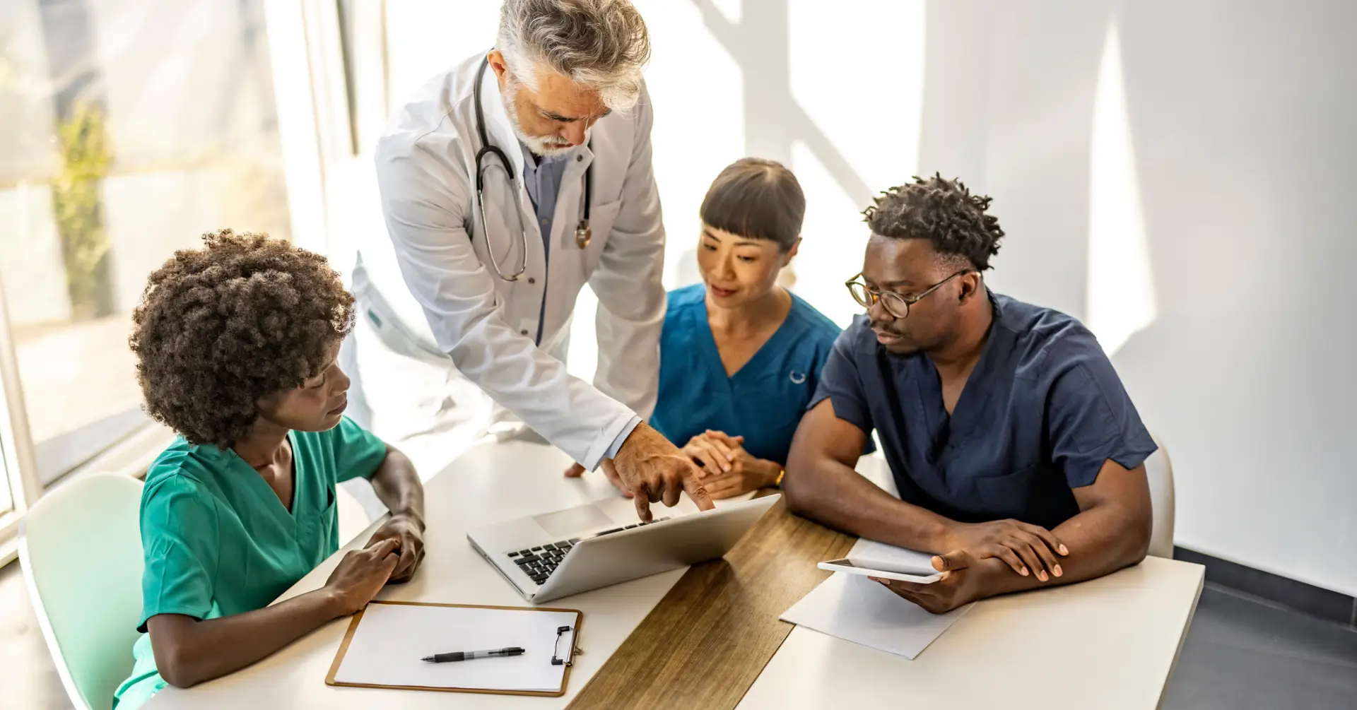 medical director talks to doctors at table