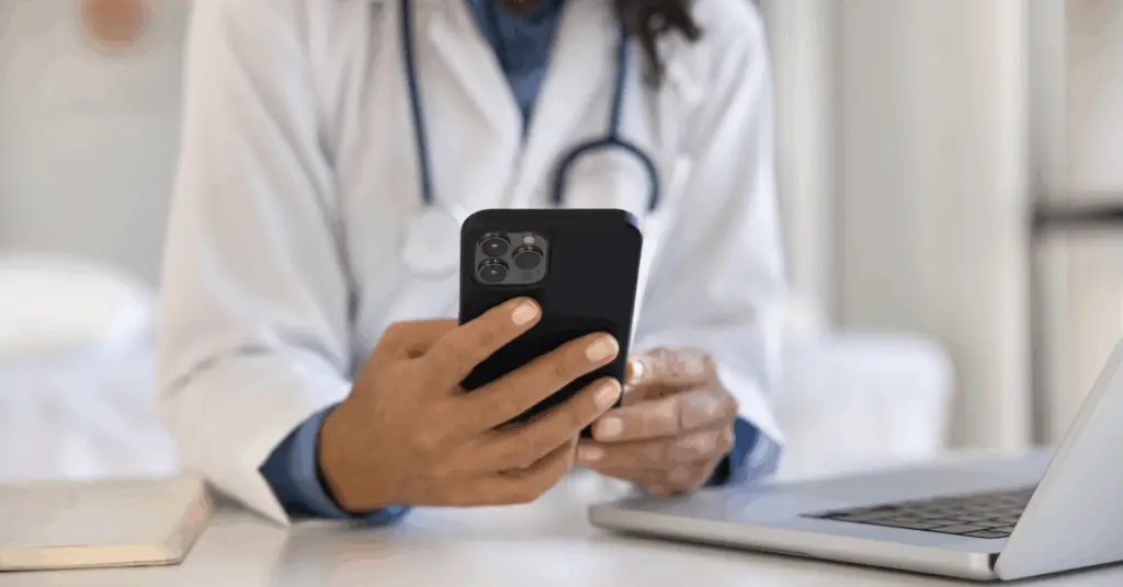 doctor using smart phone at desk