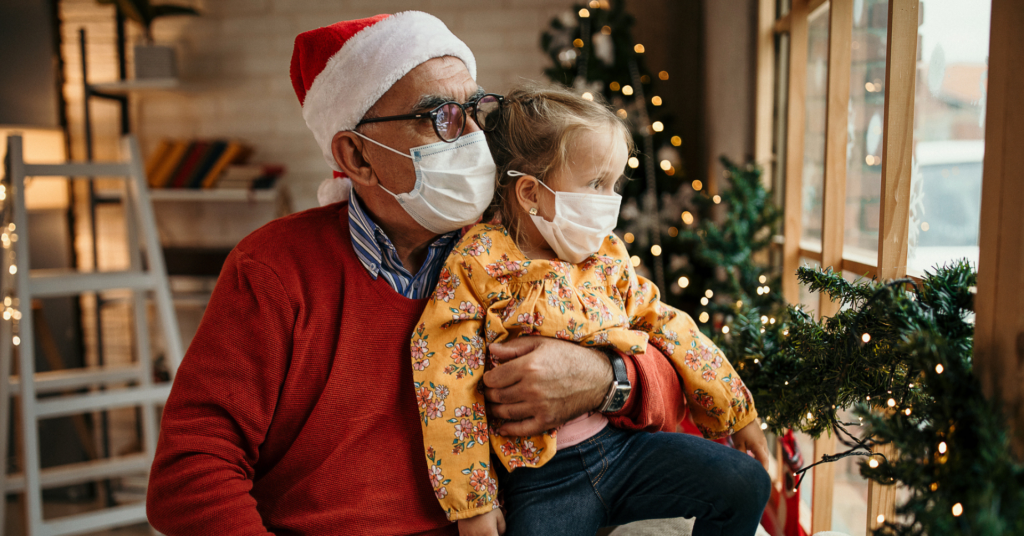 grandfather and granddaughter sit by window