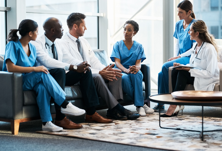 Diverse group of medical professionals discussing during a meeting.