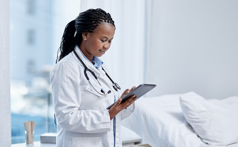 Medical professional reviewing information on a tablet.