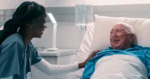 nurse at bedside with patient smiling