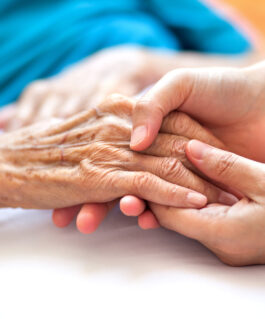 Health professional holding a patients hand.