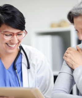 Medical professional smiles while showing information to a patient.