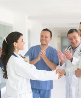 Group of medical professionals celebrating a peer's achievement.