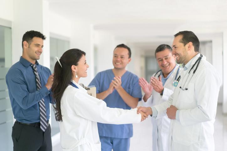 Group of medical professionals celebrating a peer's achievement.