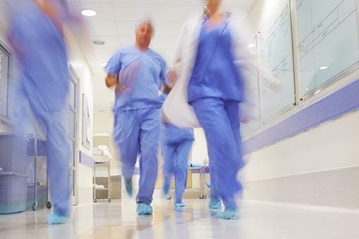 Medical professionals rushing through a corridor.