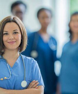 Medical professional smiling in front of peers.