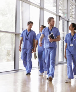 Group of medical professionals walking through a corridor.