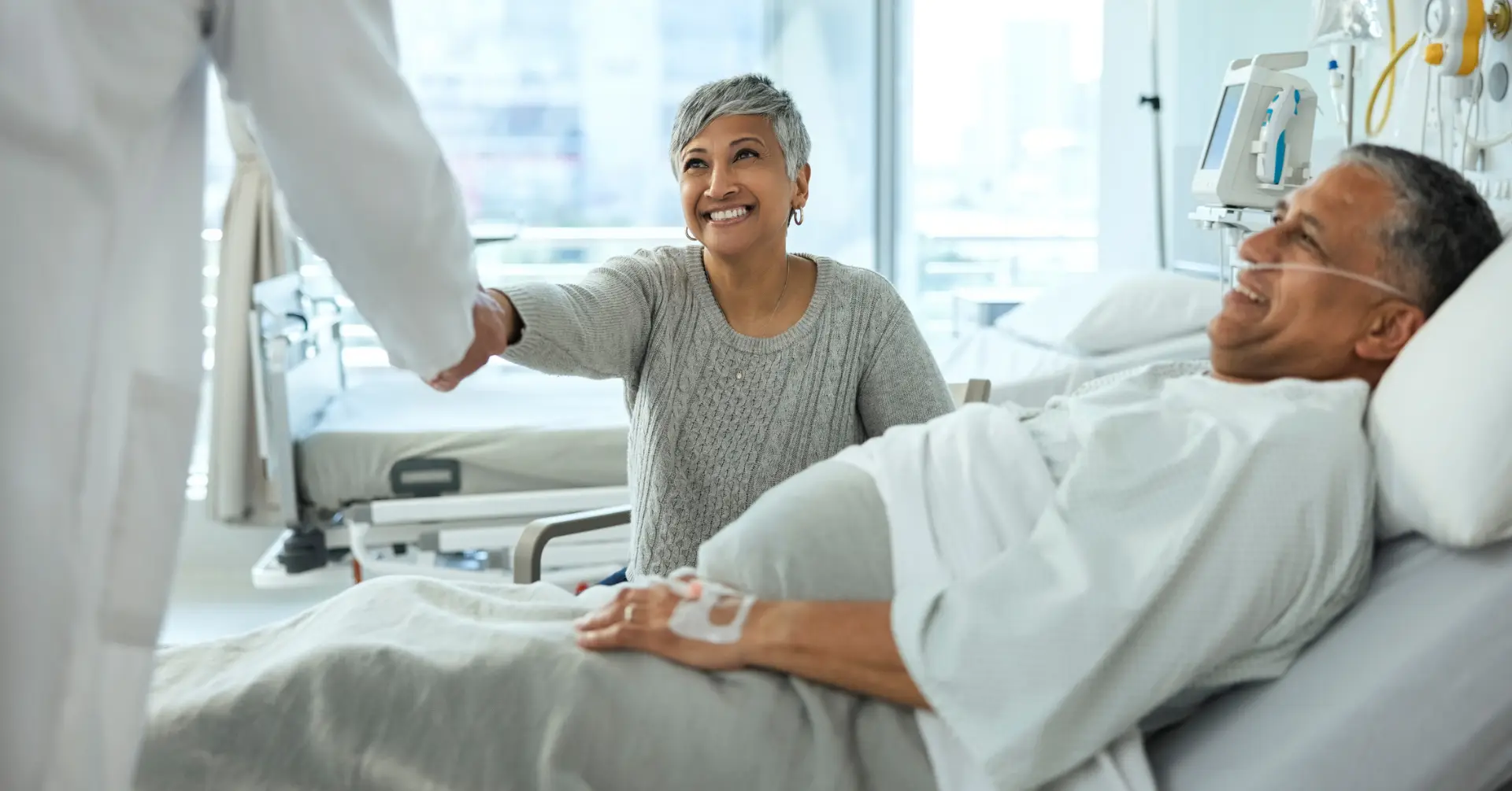 patient and relative speaking to doctor in hospital bed