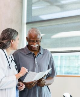 Medical professional talking over a brochure with a patient.
