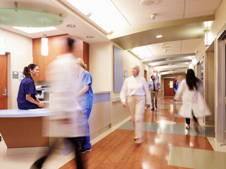Health leaders walking swiftly through hallways.
