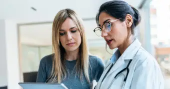 physician and patient speaking about care looking at documentation