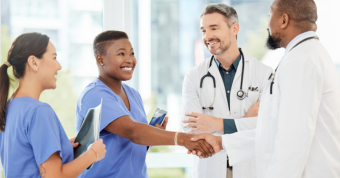group of medical professionals speaking with one another in a hospital