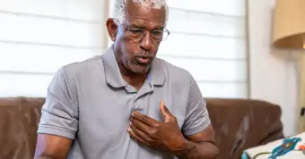 male holding his chest like he's in pain