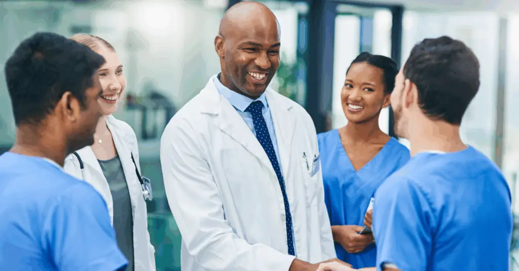 group of clinicians speaking with each other and smiling