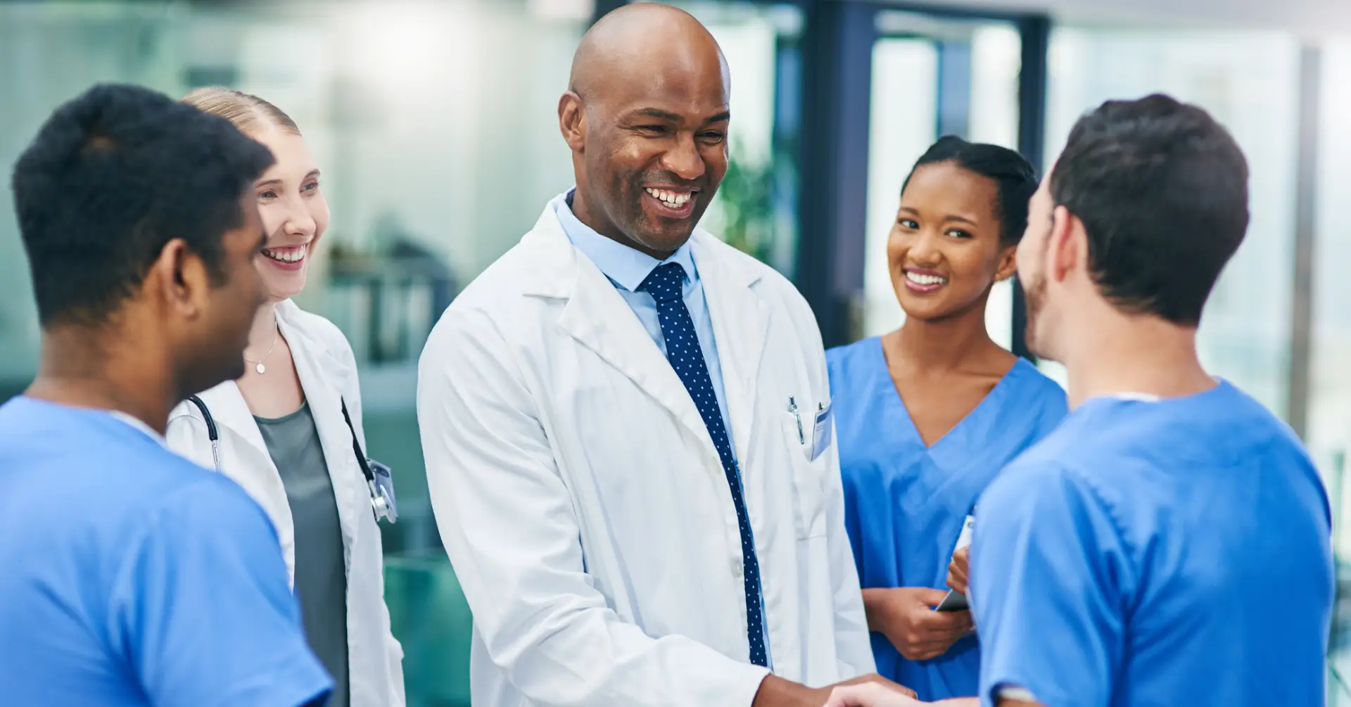 group of clinicians speaking with each other and smiling