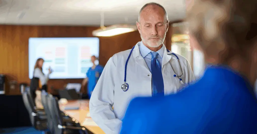 doctor looking down during a board meeting
