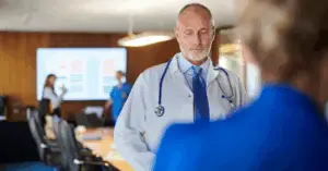 doctor looking down during a board meeting
