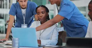 group of medical professionals brainstorming over a computer