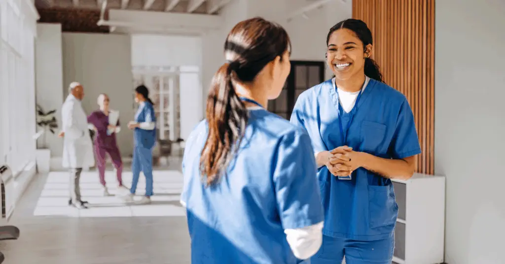 two groups of medical professionals discuss in hospital hall