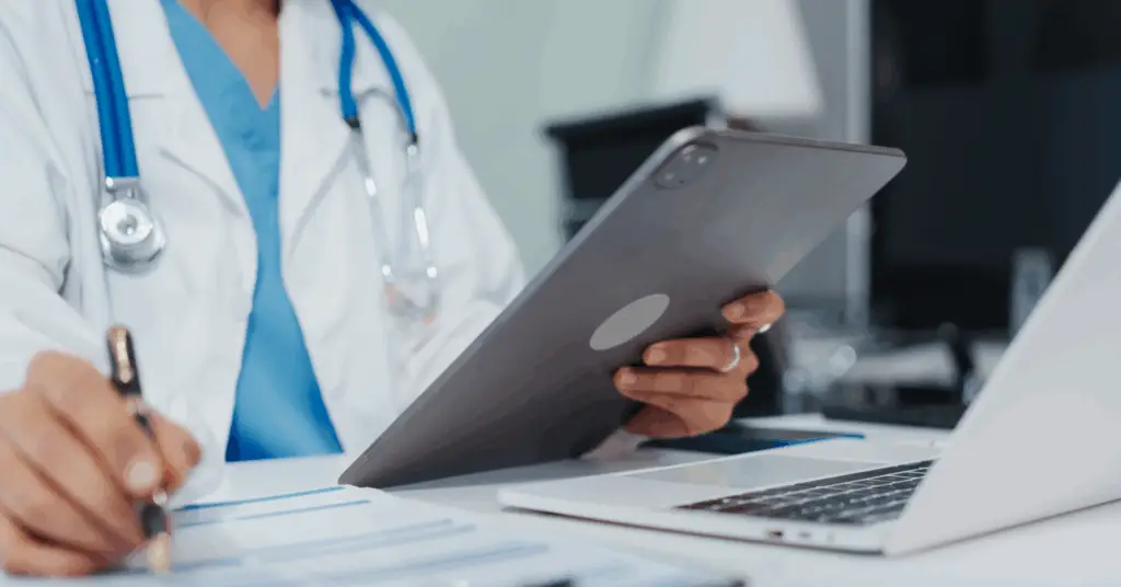 clinician working on a computer and tablet
