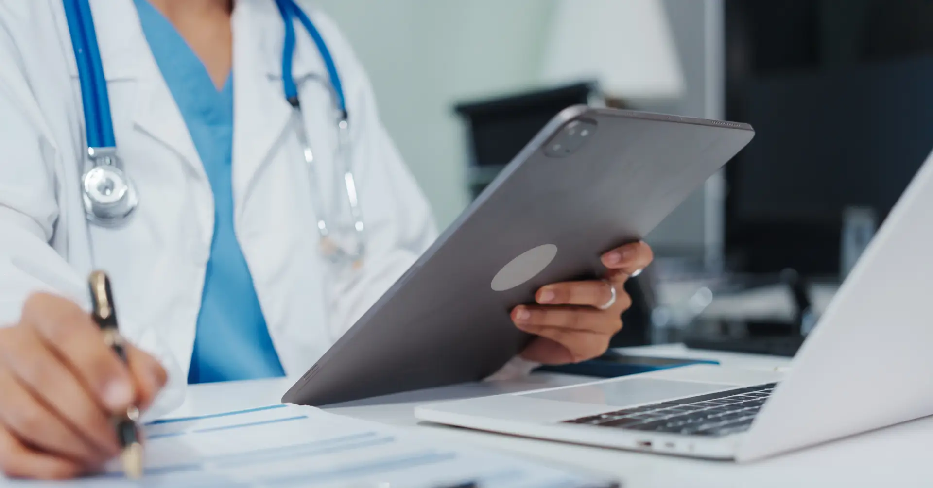 clinician working on a computer and tablet