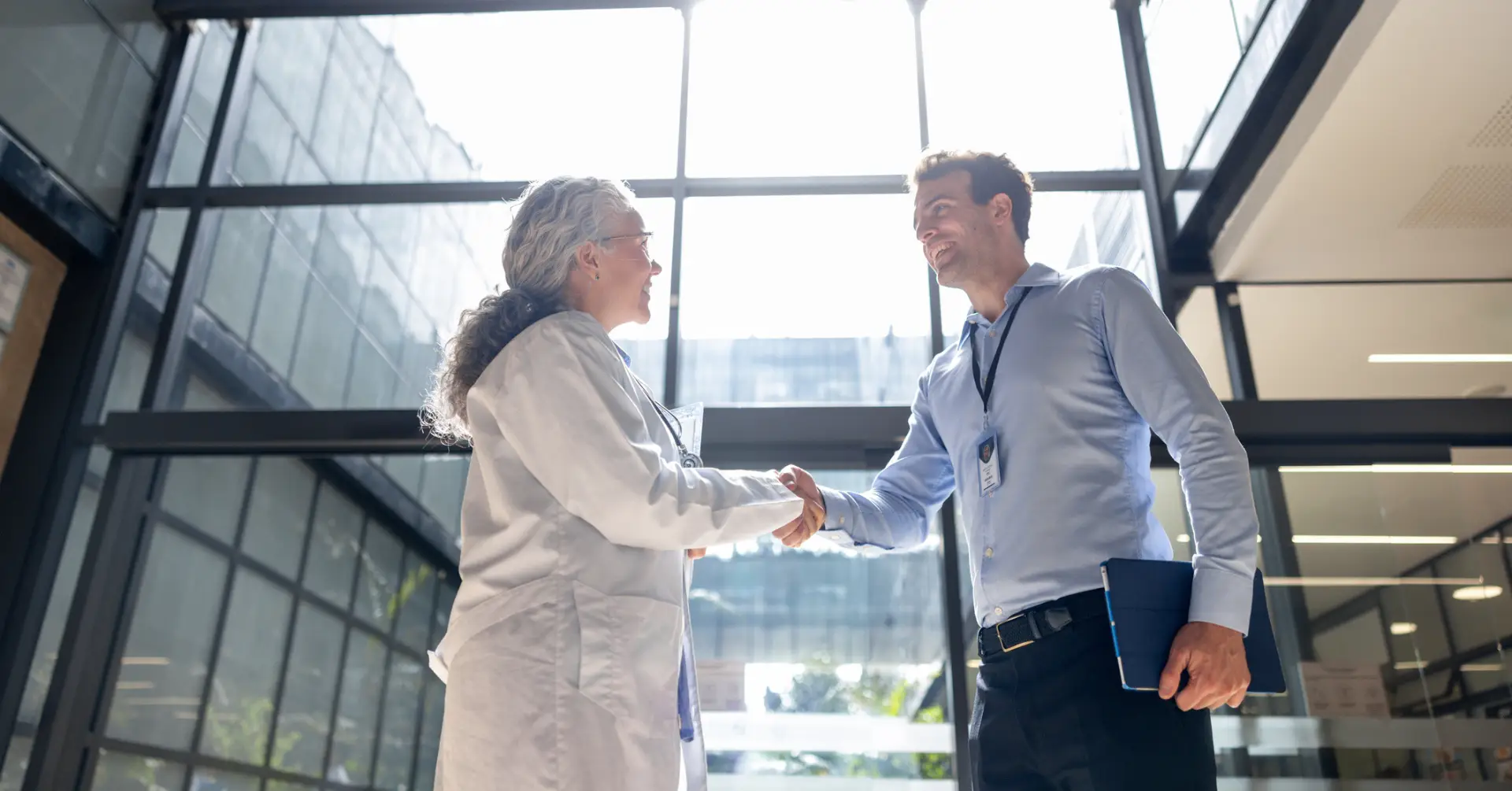 hospital executive and doctor shake hands in hospital