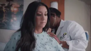 doctor conducting an exam on a female patient in hospital bed