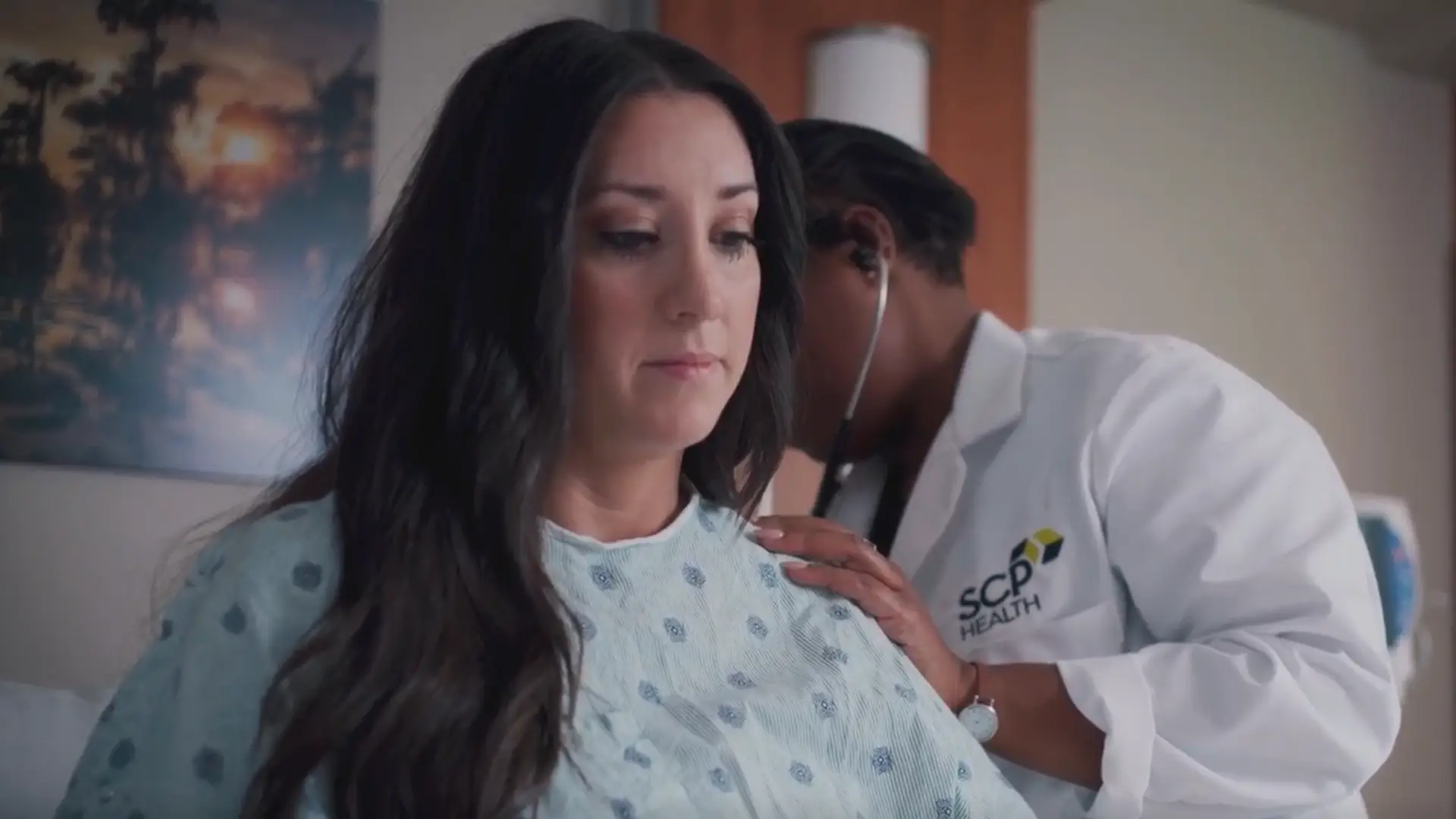 doctor conducting an exam on a female patient in hospital bed