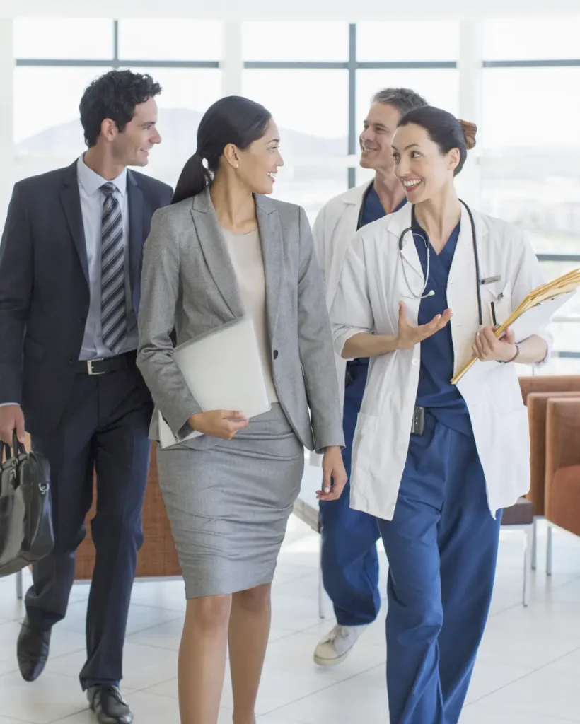 Doctors and business executives walking and talking together, reflecting healthcare social responsibility focused on building a better tomorrow.